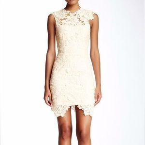 Backless white lace dress with blue sash.